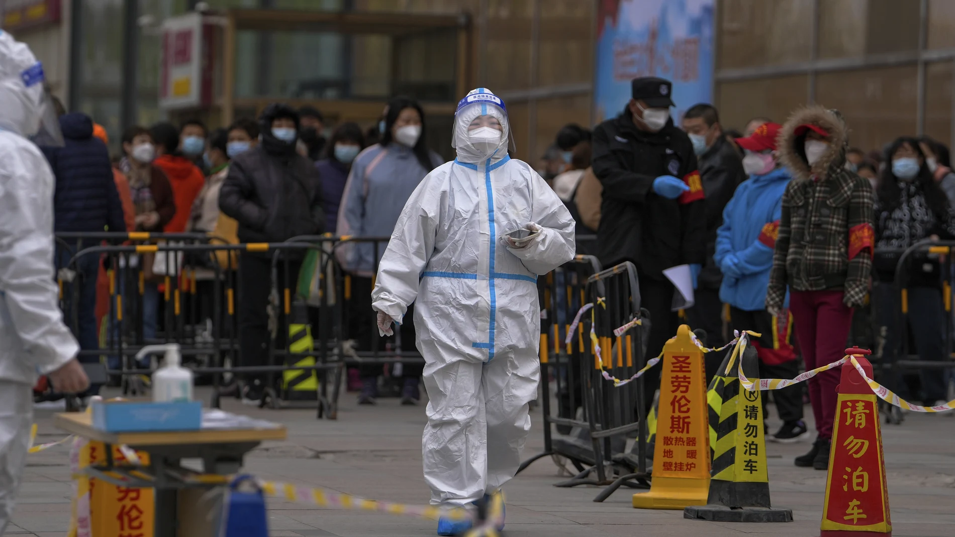 Varias personas esperan un una fila para realizarse un test de coronavirus tras detectarse un caso en un edificio residencial de Beijing