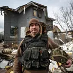 Vlad Malyshev posa con su equipamiento militar ante los restos de su casa, destruida por un misil