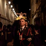 Varios componentes de una cofradía acompañan al paso del viacrucis del Cristo del Socorro durante la primera procesión de la Semana Santa 2022, en Cartagena