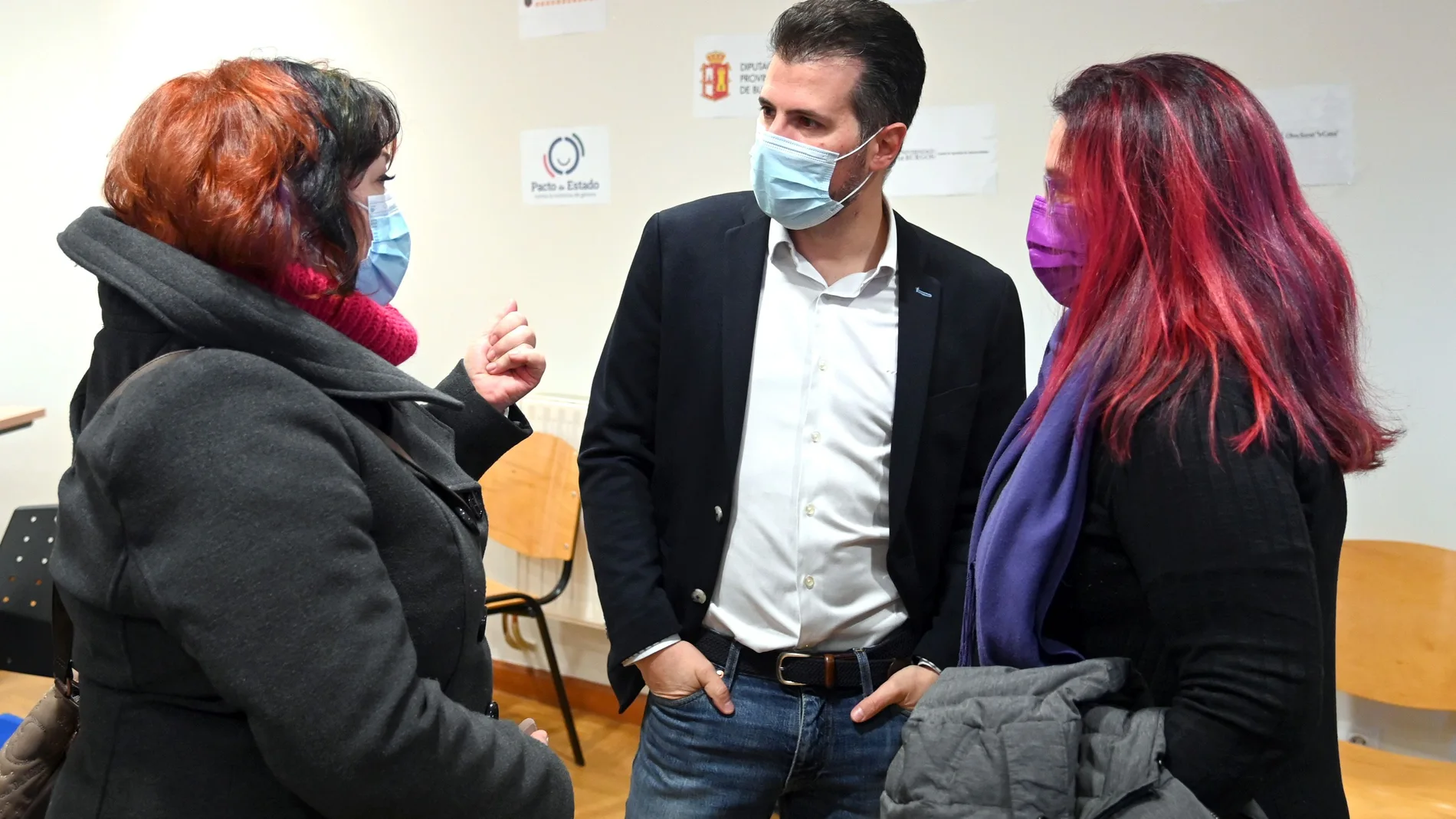 El secretario general del PSOECyL, Luis Tudanca, conversa con dos mujeres de la asociación feminista "La Rueda" de Burgos