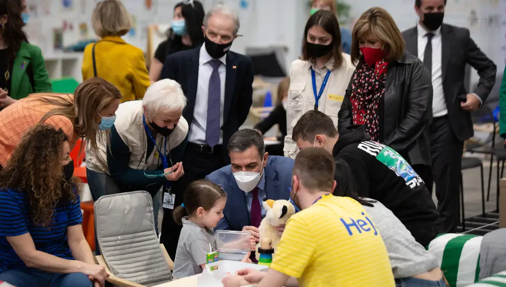 El presidente del Gobierno, Pedro Sánchez con una niña, durante su visita al centro de refugiados ucranianos , en la Fira de Barcelona