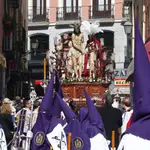 Varias personas visten capirotes y trajes cofrades en la procesión de Domingo de Ramos de la Hermandad del Silencio