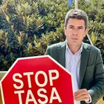 El presidente del PPCV, Carlos Mazón, con un cartel de la campaña &#39;Stop a la tasa turística&#39;