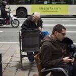 Un señor mayor busca en una papelera de la calle, en Madrid