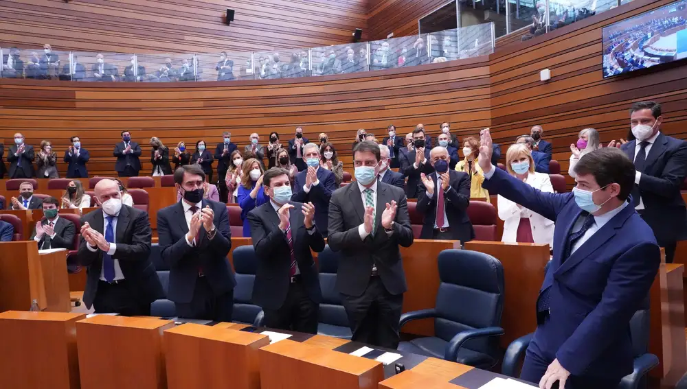 Fernández Mañueco saluda desde su escaño tras recibir el aplauso de los suyos tras una de sus intervenciones