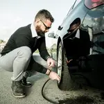 Hombre comprobando la presión de los neumáticos
