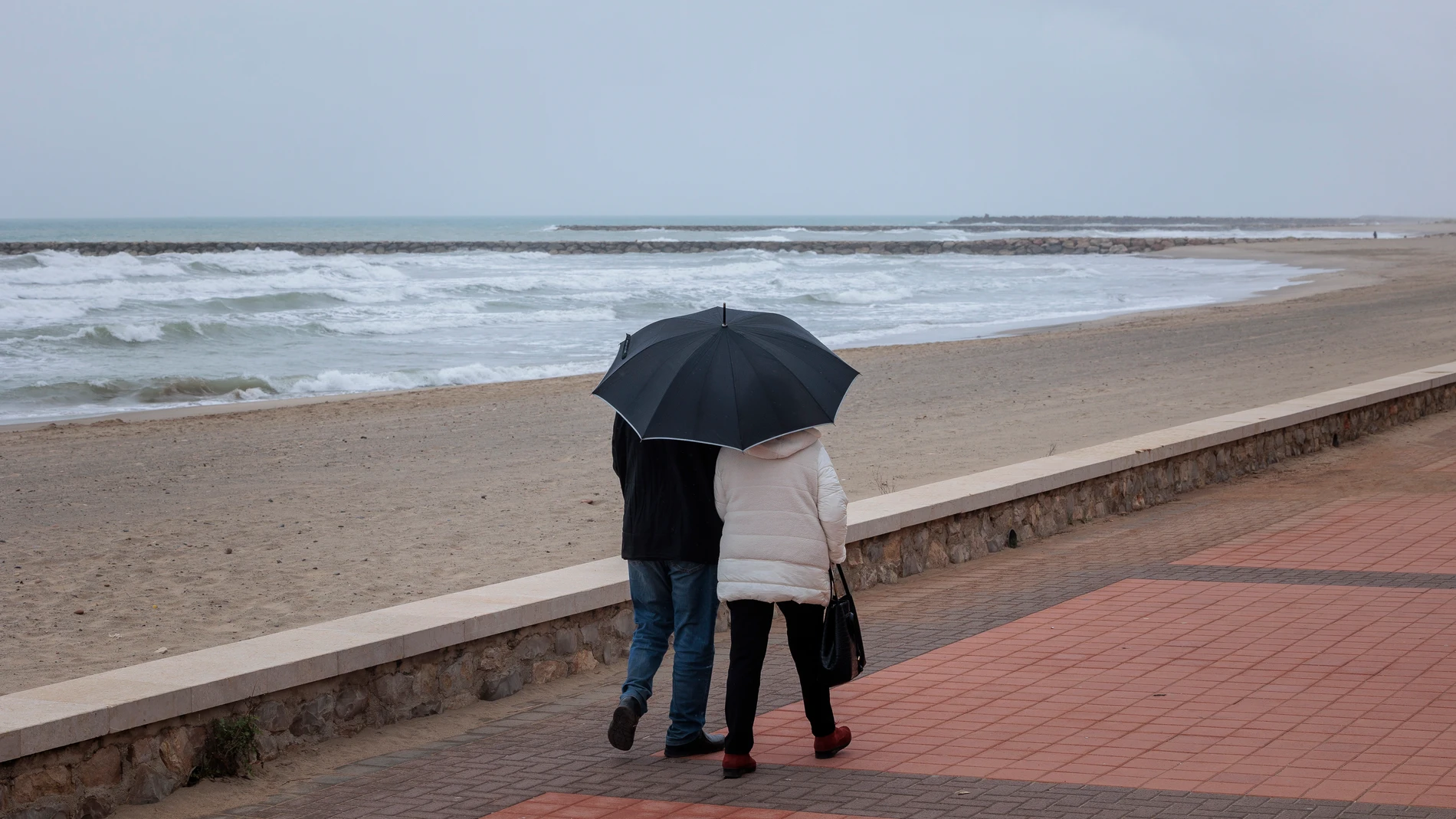 Una parejase protege de la lluvia con un paraguas