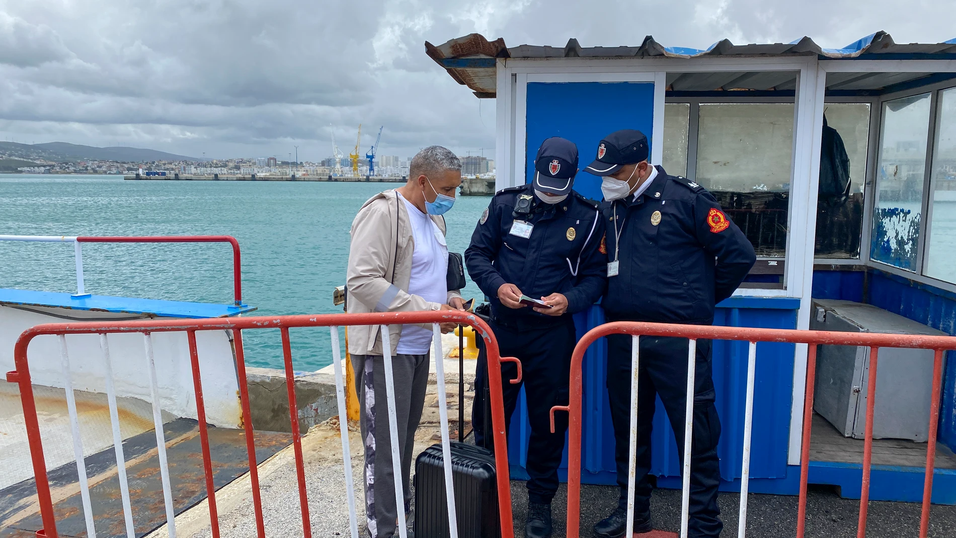 Un pasajero enseña la documentación a la policía marroquí a su llegada al puerto de Tánger (Marruecos) en el primer barco procedente de Tarifa