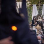 Un nazareno acompaña, el Miércoles Santo, al paso de la Cofradía de la Santa Cruz por las calles de Huelva