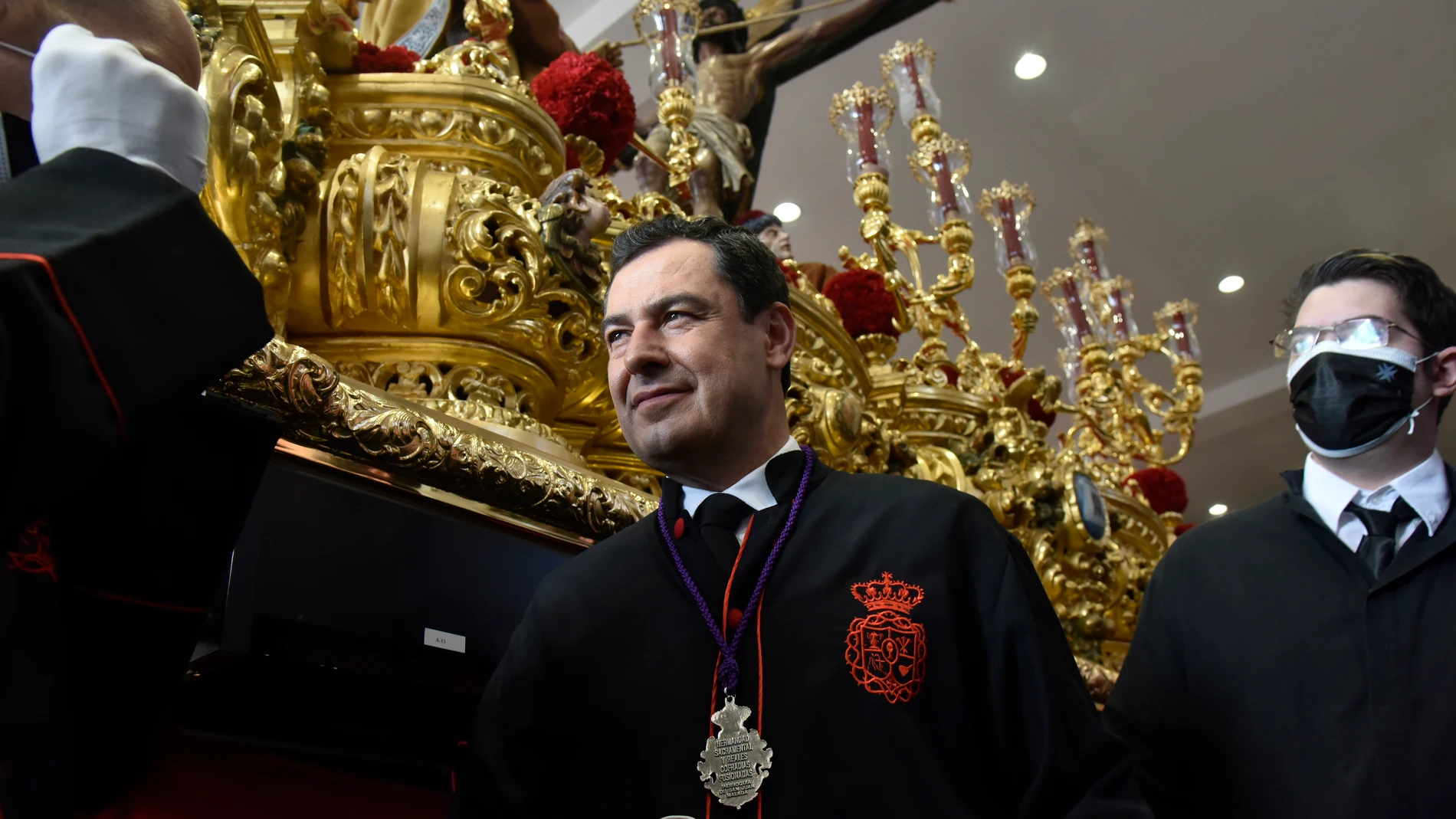 El presidente de la Junta de Andalucía, Juanma Moreno, a la llegada a el templo para participar como un hombre de trono del Cristo de la Exaltación. Álex Zea / Europa Press