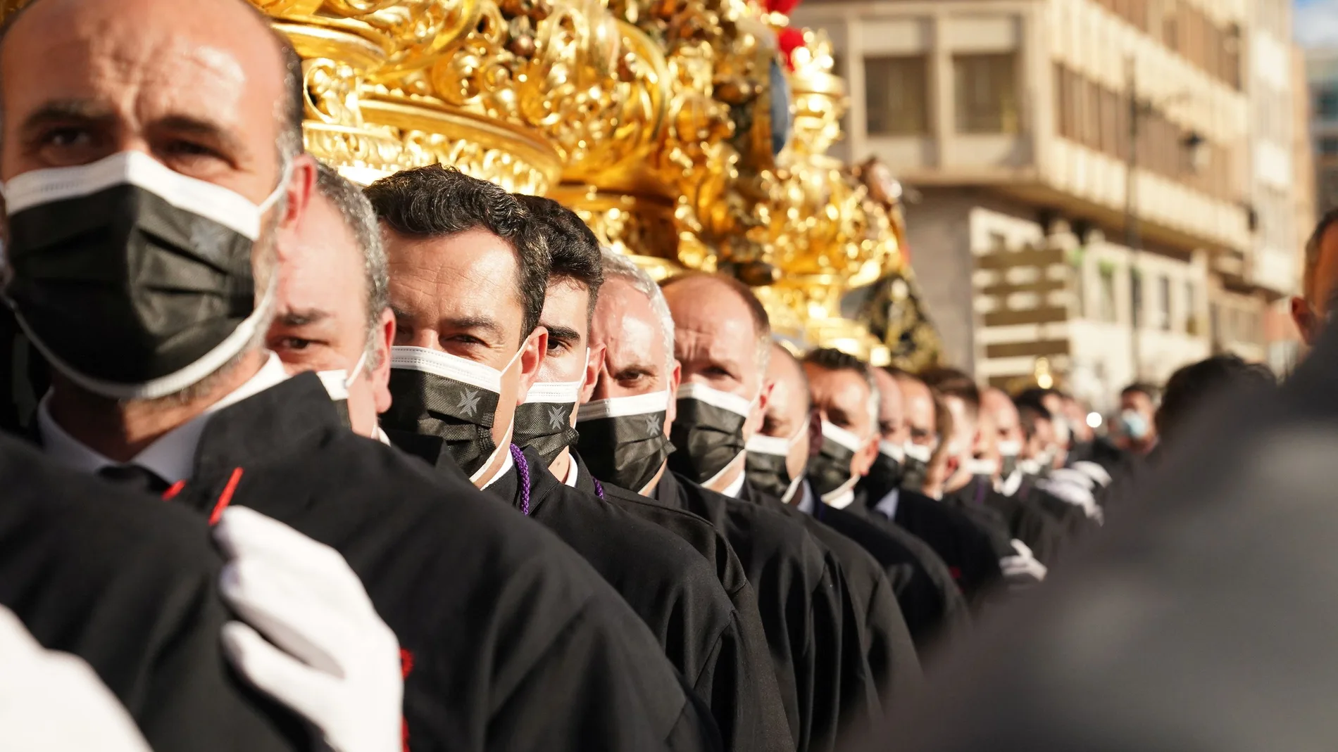 El presidente de la Junta, Juanma Moreno, porta el trono del Cristo de la Exaltación