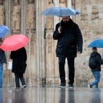 Varias personas pasean bajo la lluvia en Valencia