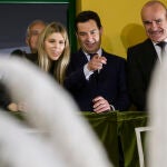 El presidente de la Junta de Andalucía, Juanma Moreno (c); su mujer, Manuela Villena (i), y el alcalde de sevilla, Antonio Muñoz (d) observan a los "Armaos" de la Centuria Macarena en la salida de la procesión, esta Madrugá en Sevilla. EFE/ Raúl Caro