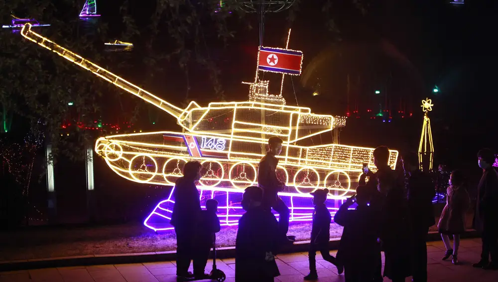 Norcoreanos pasean frente a un tanque iluminado con motivo del nacimiento de Kim Il Sung hace 110 años