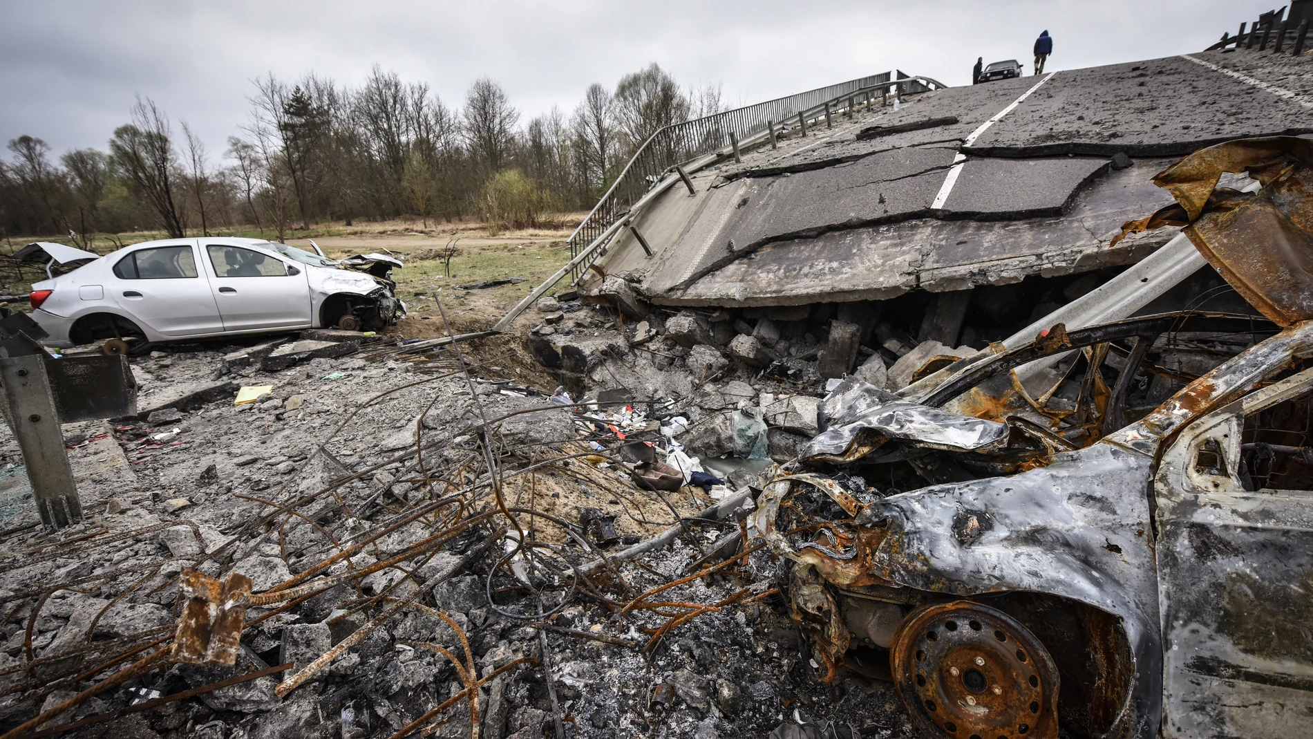 Un hombre camina por un puente destruido en la zona de Kiev