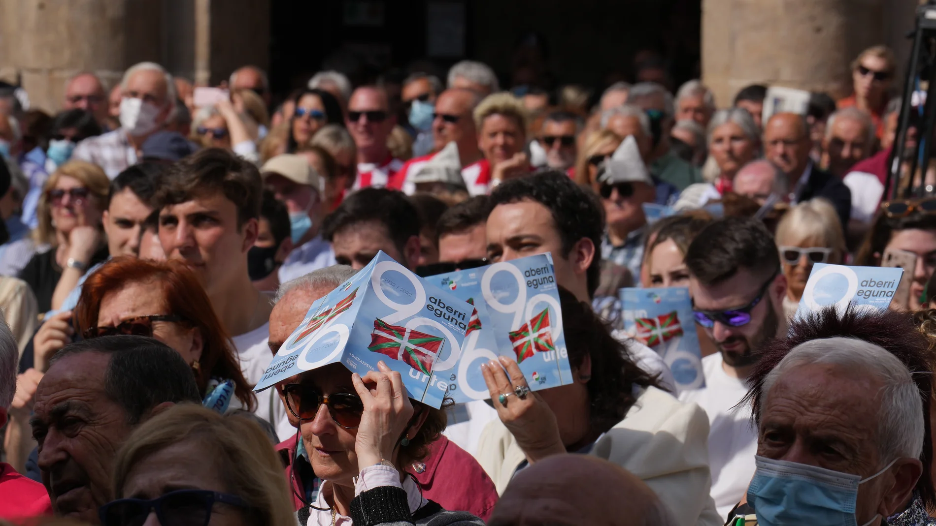 Una participante se protege del sol durante un acto en la celebración del Aberri Eguna en Plaza Nueva de Bilbao, a 17 de abril de 2022