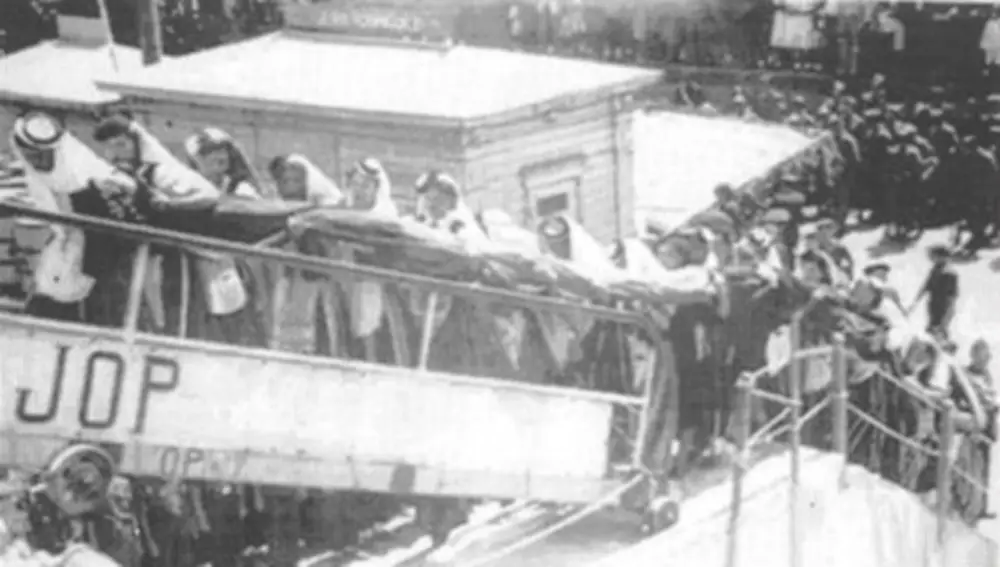 1940. Un grupo de jóvenes, ataviadas con el traje típico, trasladan la bandera de combate a bordo del «Canarias»