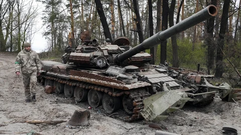 Un soldado ucraniano pasa junto a un carro de combate ruso destruido por los combates en Moshchun, cerca de Kiev