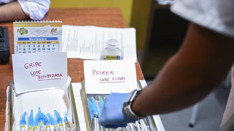 Dos bandejas, con vacunas contra la gripe y con terceras dosis de la vacuna contra el Covid-19