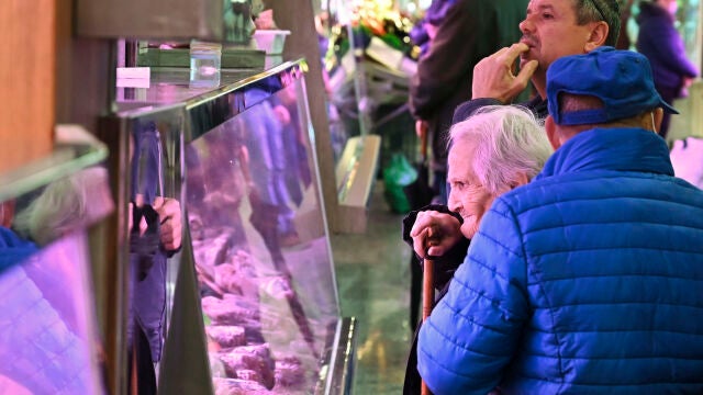 Un par de clientes sin mascarilla aguardan a ser atendidos un mercado de Madrid