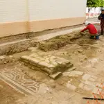 Un técnico limpia los fragmentos aparecidos de un mosaico romano del siglo IV o finales del III en Tocina (Sevilla)