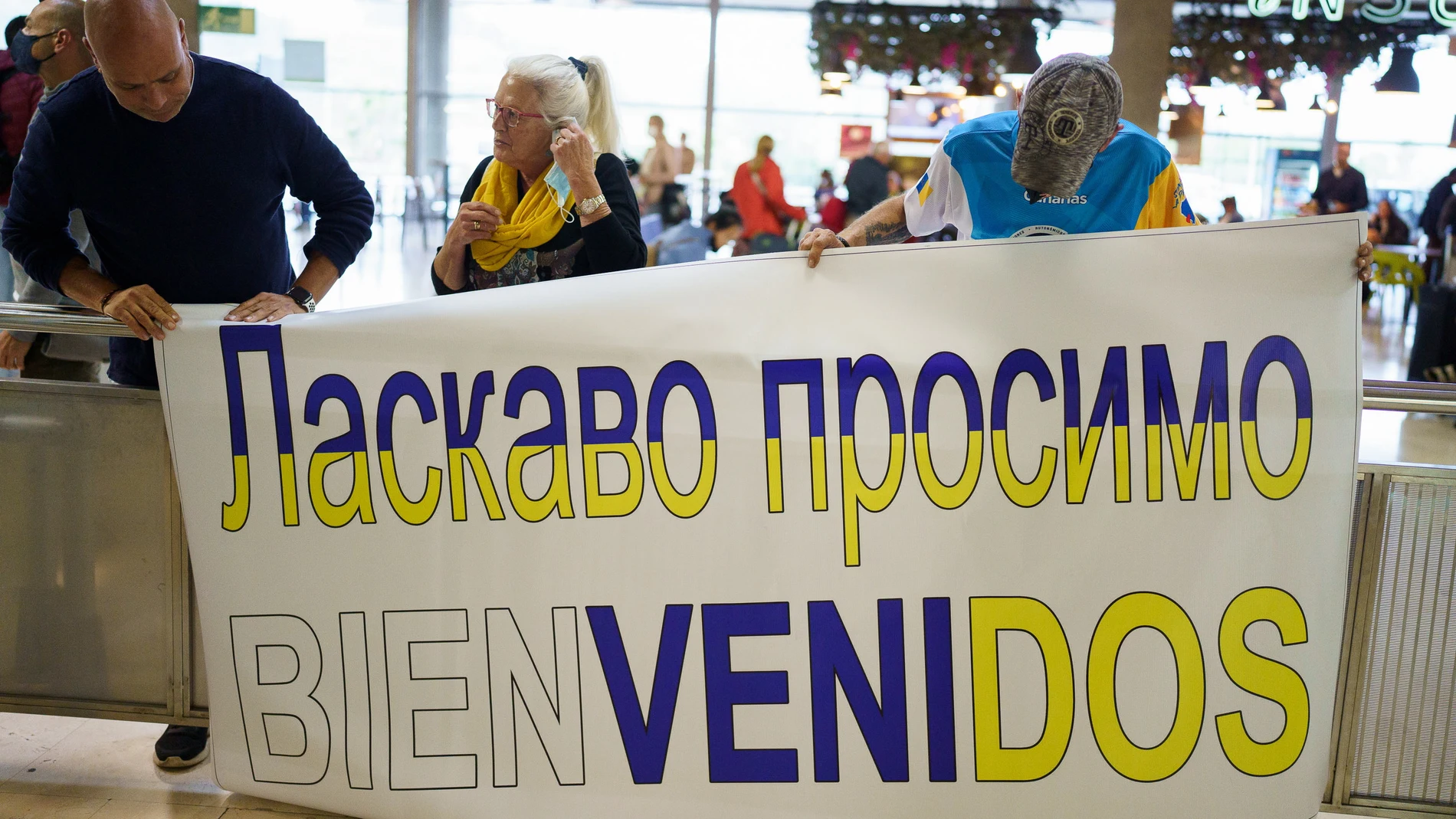 Familias de acogida esperan en la terminal de llegadas del aeropuerto Tenerife Norte