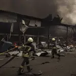 Los bomberos trabajan para extinguir un incendio en un almacén en medio de bombardeos rusos en Jarkov