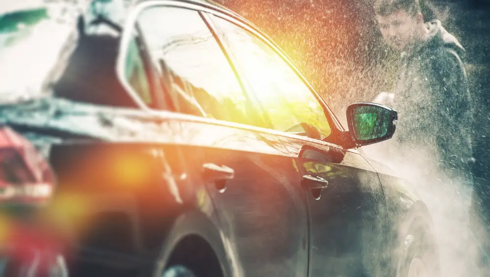 En la imagen, un hombre limpia su coche con agua a presión | Fuente: Dreamstime