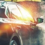 En la imagen, un hombre limpia su coche con agua a presión | Fuente: Dreamstime