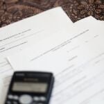 Una calculadora sobre un contrato de compraventa de vivienda y un contrato de arrendamiento