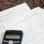 Una calculadora sobre un contrato de compraventa de vivienda y un contrato de arrendamiento