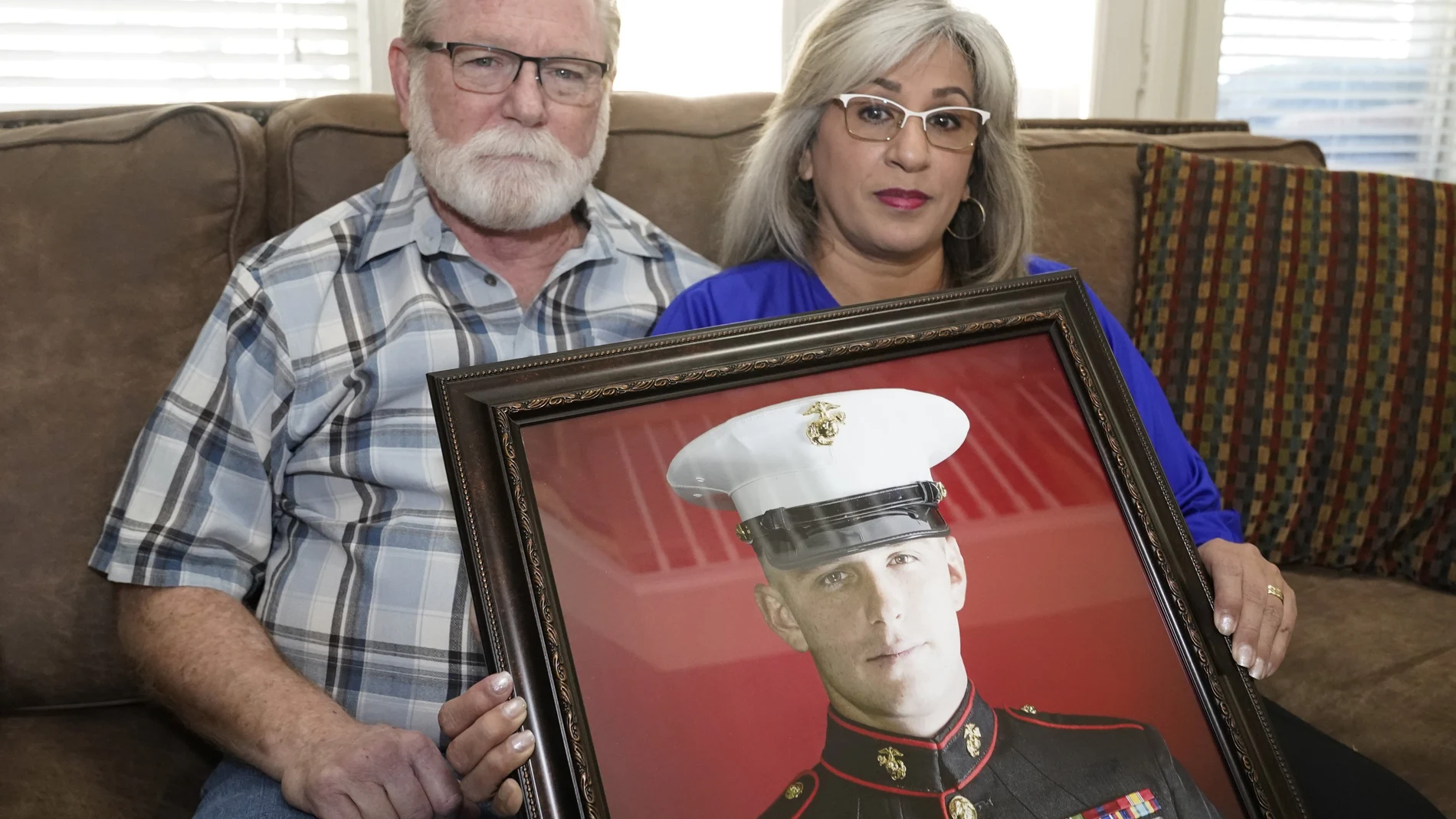 Joey Y Paula Reed posan con un retrato de su hijo Trevor, detenido en Rusia