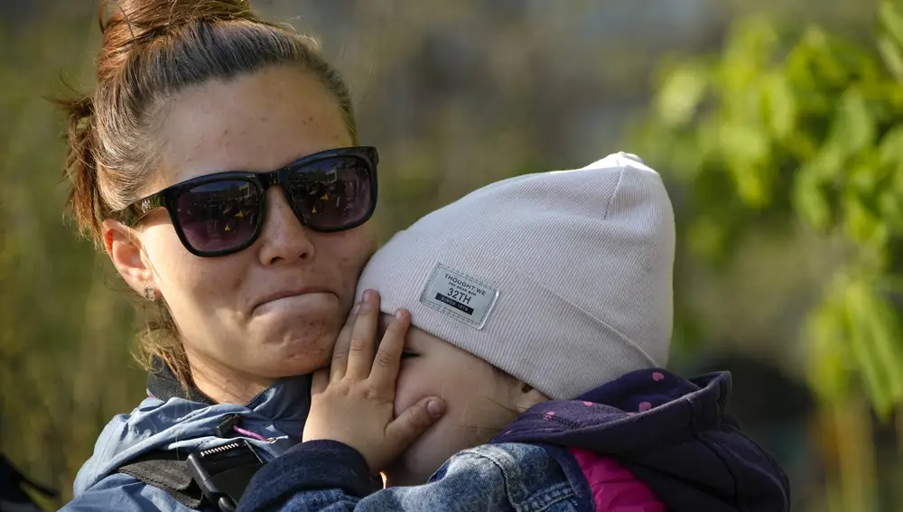 Una mujer ucraniana hace cola con su bebé para recibir ayuda humanitaria FOTO: ALEXANDER ZEMLIANICHENKO AP