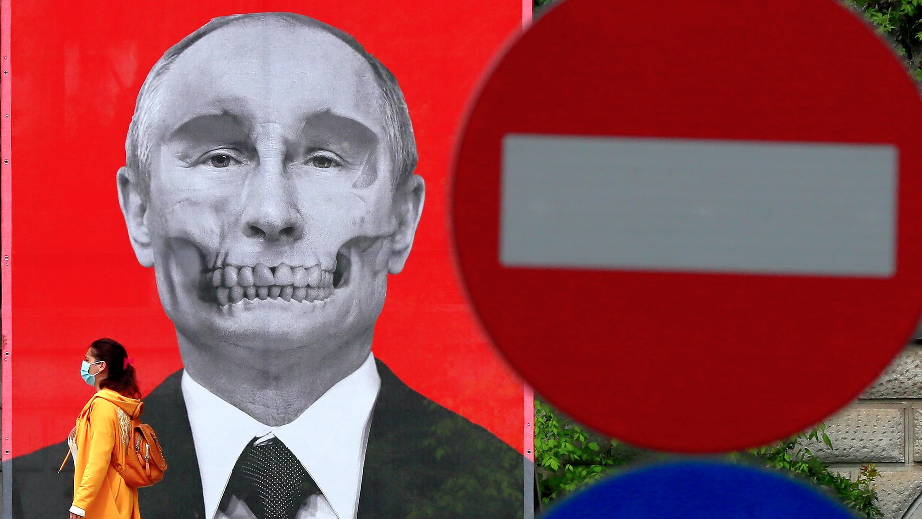 Una mujer pasa junto a un póster que representa al presidente ruso Vladimir Putin en Bucarest.