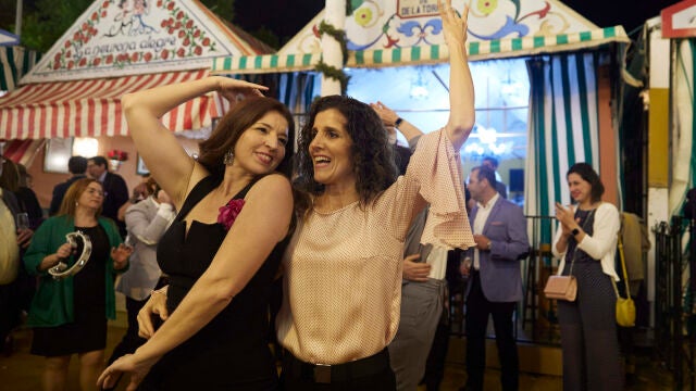 Dos mujeres bailan una sevillana en una calle de la Feria en esta noche del pescaíto y del alumbrao