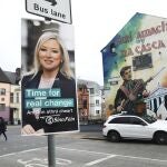 Un cartel electoral del Sinn Fein junto a un mural en Belfast