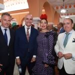 El alcalde de Sevilla, Antonio Muñoz (segundo por la izquierda), atiende a varios invitados durante la recepción de este martes en la caseta municipal, entre ellos la empresaria y exmodelo Raquel Revuelta