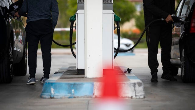 Dos conductores repostando en una gasolinera