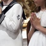 Un niño y una niña antes de tomar la primera comunión