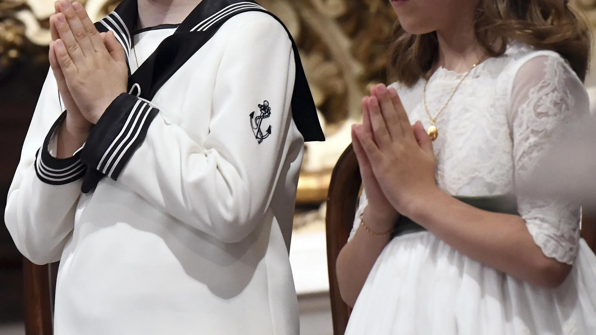 Un niño y una niña antes de tomar la primera comunión