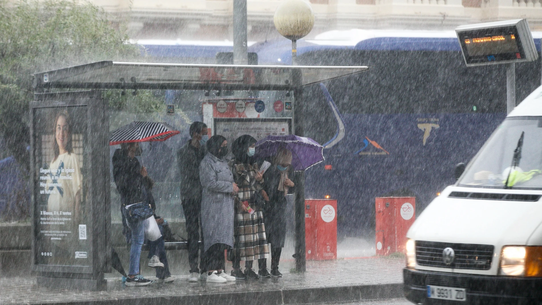 Varios ciudadanos se protegen en una parada de autobús de las lluvias torrenciales de ayer miércoles sobre Murcia capital