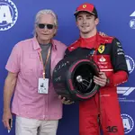 El piloto de Ferrari, Charles Leclerc, posa con el actor Michael Douglas tras conseguir el mejor tiempo en parrilla de salida (AP Photo/Darron Cummings)