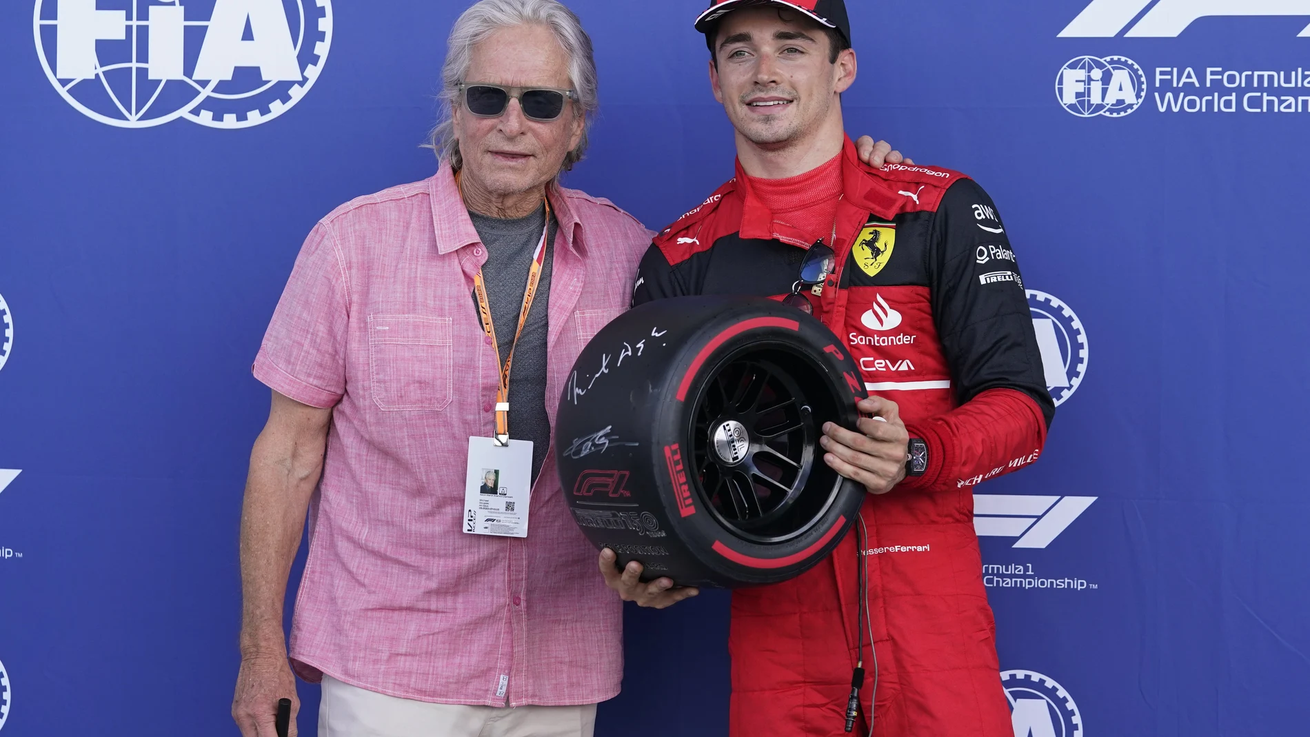 El piloto de Ferrari, Charles Leclerc, posa con el actor Michael Douglas tras conseguir el mejor tiempo en parrilla de salida (AP Photo/Darron Cummings)