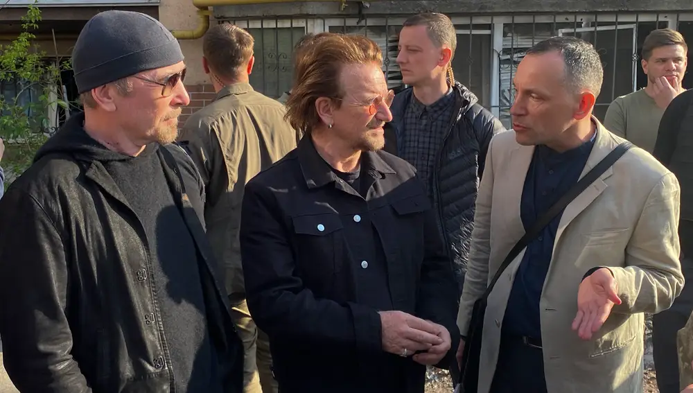 Bono (c), el músico irlandés de la banda U2, durante su visita este domingo en la localidad ucraniana de Irpin.- EFE/Lourdes Velasco