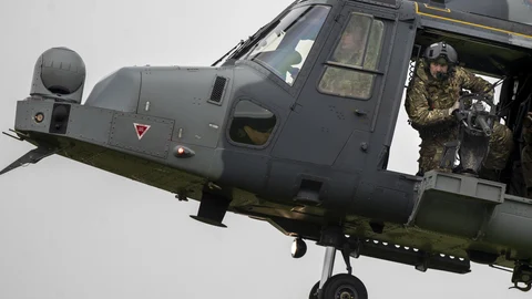 Un soldado del Ejército británico mira hacia abajo desde un helicóptero AgustaWestland AW159 Wildcat durante el ejercicio militar de la OTAN "Flaming Sword 2022" en un campo de entrenamiento cerca del pueblo Maisiejunai, a unos 96 km al oeste de la capital lituana
