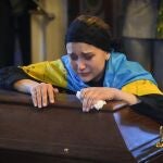 La viuda del soldado voluntario Oleksandr Makhov, de 36 años, conocido periodista ucraniano, asesinado por las tropas rusas, llora sobre su féretro en la catedral de San Miguel de Kyiv