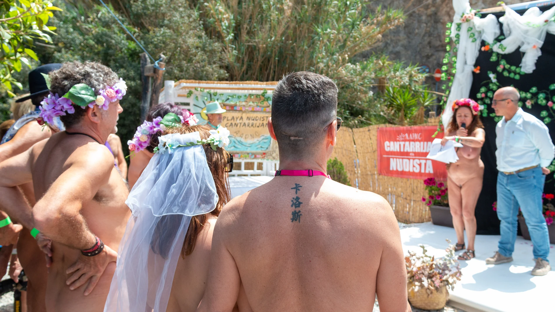 Un momento de la boda nudista multitudinaria que se ha celebrado hoy sábado en la playa de Cantarriján (Almuñécar), en la costa de Granada