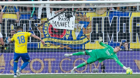 El guardameta ucraniano del Real Madrid, Andriy Lunin (d), detiene el lanzamiento desde el punto de penalti por parte del delantero del Cádiz, Álvaro Negredo, durante el encuentro correspondiente a la jornadaa 37 de primera división que disputan hoy domingo en el estadio Nuevo Mirandilla, en la capital gaditana. EFE/Román Ríos.