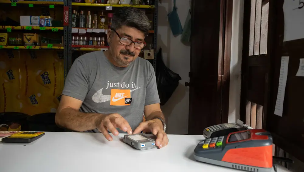 Un hombre realiza el cobro de productos en una tienda de abastos, el 14 de mayo de 2022, en Caracas (Venezuela)
