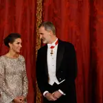 El rey Felipe VI conversa con la reina Letizia (i) a su llegada a la cena de gala ofrecida al emir de Catar, Tamim bin Hamad Al Thani, y su esposa este martes en el Palacio Real, en Madrid.